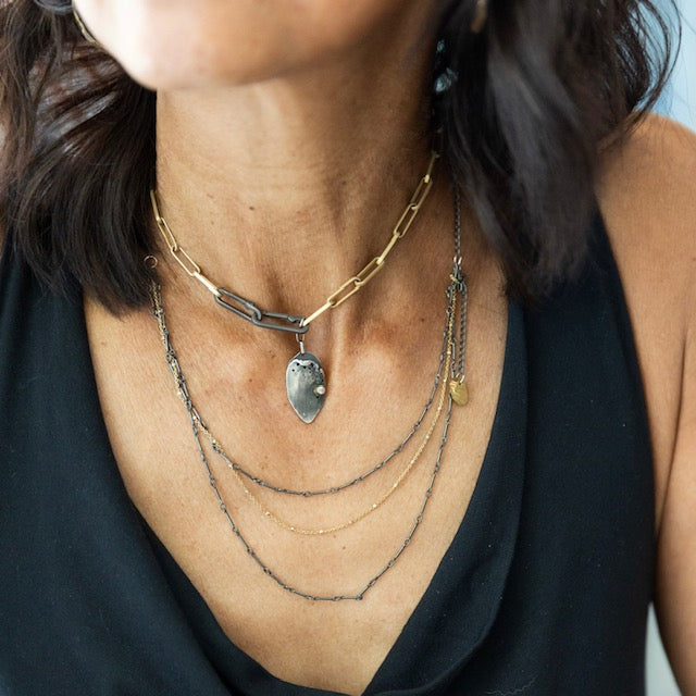 A delicate and stunning necklace! Get the look of layers in one simple beauty with the Layered Necklace in Mixed Metal. Shown with the Modern Gold Link Chain with Double Paper Clip Clasp and Desire Talisman.