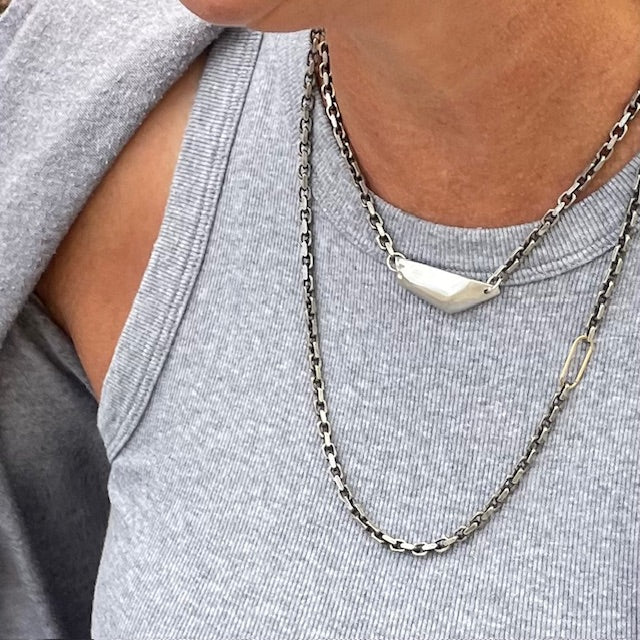 Vestige Necklace in Silver Layered with Spark Chain Necklace on a person 