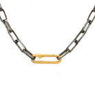 An oxidized silver chain necklace with a gold paper clip connector serving as the clasp, positioned against a white background.