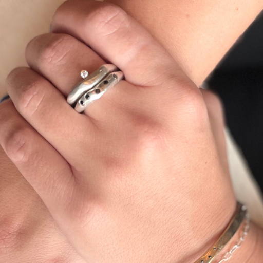 Close up of Odyssey & Constellation Rings in Silver on hand 