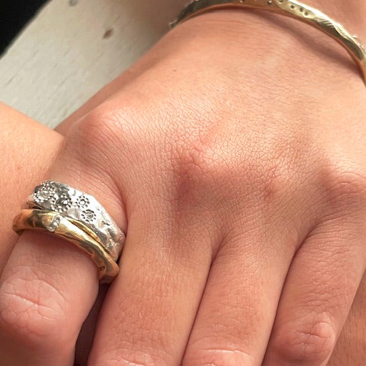 Close-up of a hand wearing Channel Ring in Bronze and Thrive Ring
