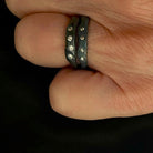 Close-up of a hand wearing two Deep Mystic Rings with Diamonds 