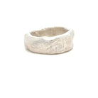Silver ring with a textured surface on a white background