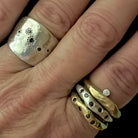 The Five Elements Ring in Silver with other stacking rings shown on persons hand 
