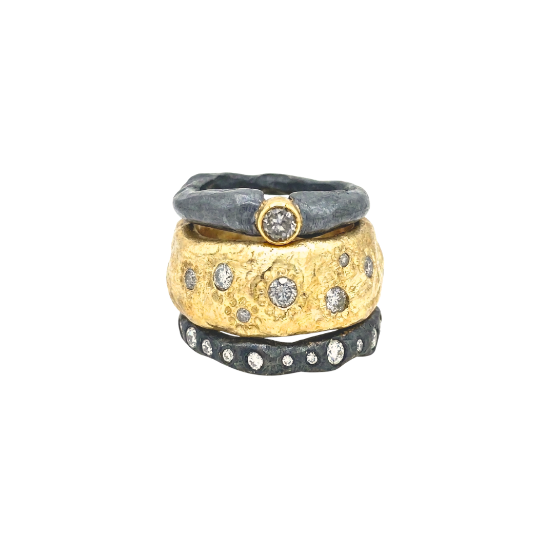 Thrive Ring in bronze with salt and pepper diamonds shown with Devotion Ring in oxidized silver with salt and pepper diamond and Mystic Radiance Ring. 