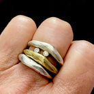Close up of Silver and Bronze Odyssey Rings with Silver Element Ring on hand