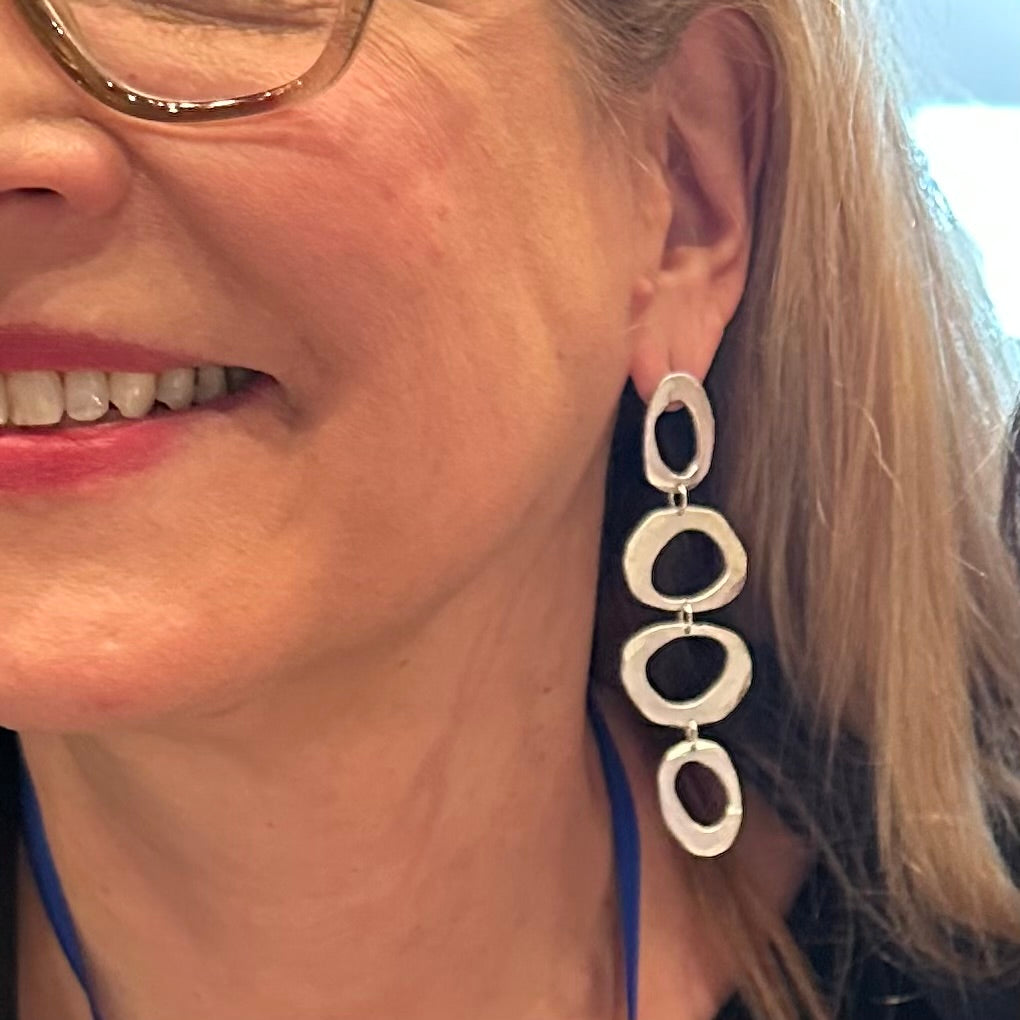 Close up of Mystic Statement Earrings in Silver on a person