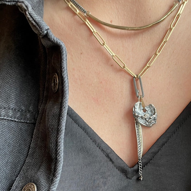 Close-up of Love Talisman Pendant with Strength Talisman Pendant with Black Diamond. Layered with Bar Necklace in Bronze. 