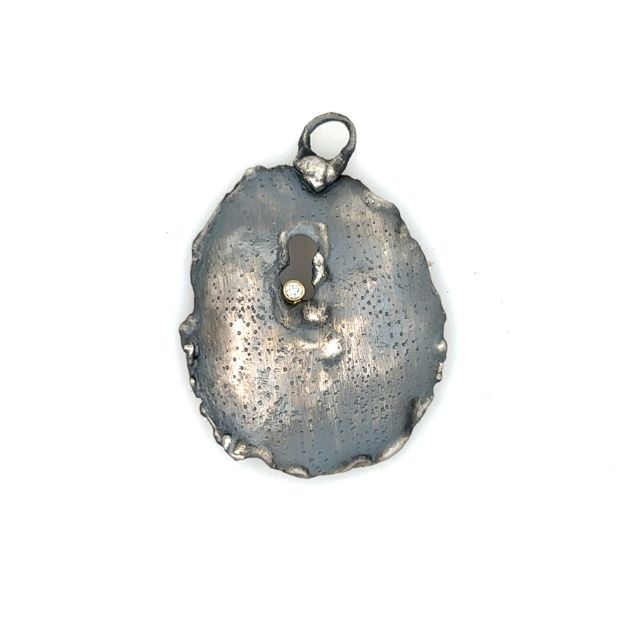 The Awaken Talisman Pendant is a talisman for stirring your soul and stepping fully into your truth.

A hand-sculpted form, raw and organic, bears a burnished opening at its center, a reminder that awakening often begins with the fire that breaks us open. From this hollow, a brilliant diamond shines - the light of resilience, clarity, and possibility.