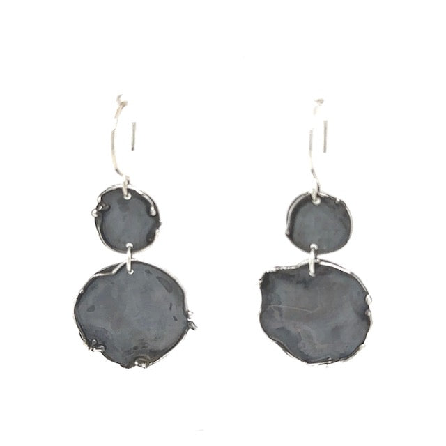 Experience the raw beauty of Whidbey Island's twilight hours with our Twilight Drop Earrings. They feature two oxidized discs with uniquely molten edges, evoking the island's rugged shorelines as day melts into night.