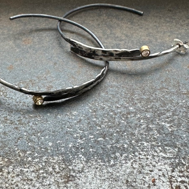 As you wear these hoops, feel the duality of nature's forces. The cool, moody silver represents the depths and mysteries of the sea, while the diamonds in gold settings symbolize hope and light breaking through. This juxtaposition serves as a reminder that even in life's stormiest moments, beauty and brilliance persist.