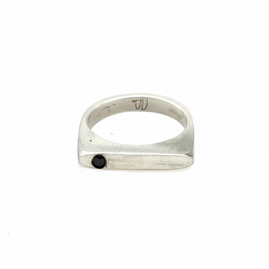 This sleek, architectural band captures that moment of clarity with its refined silhouette and single black diamond - like the dark center of an eclipse where revelation occurs in shadow.