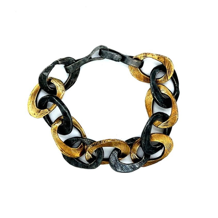 This exquisite piece combines the warmth of bronze and the cool sophistication of oxidized sterling silver in a harmonious design. This bracelet features intricately woven strands that symbolize the interconnectedness of life's experiences. The adjustable clasp ensures a perfect fit for any wrist size. 